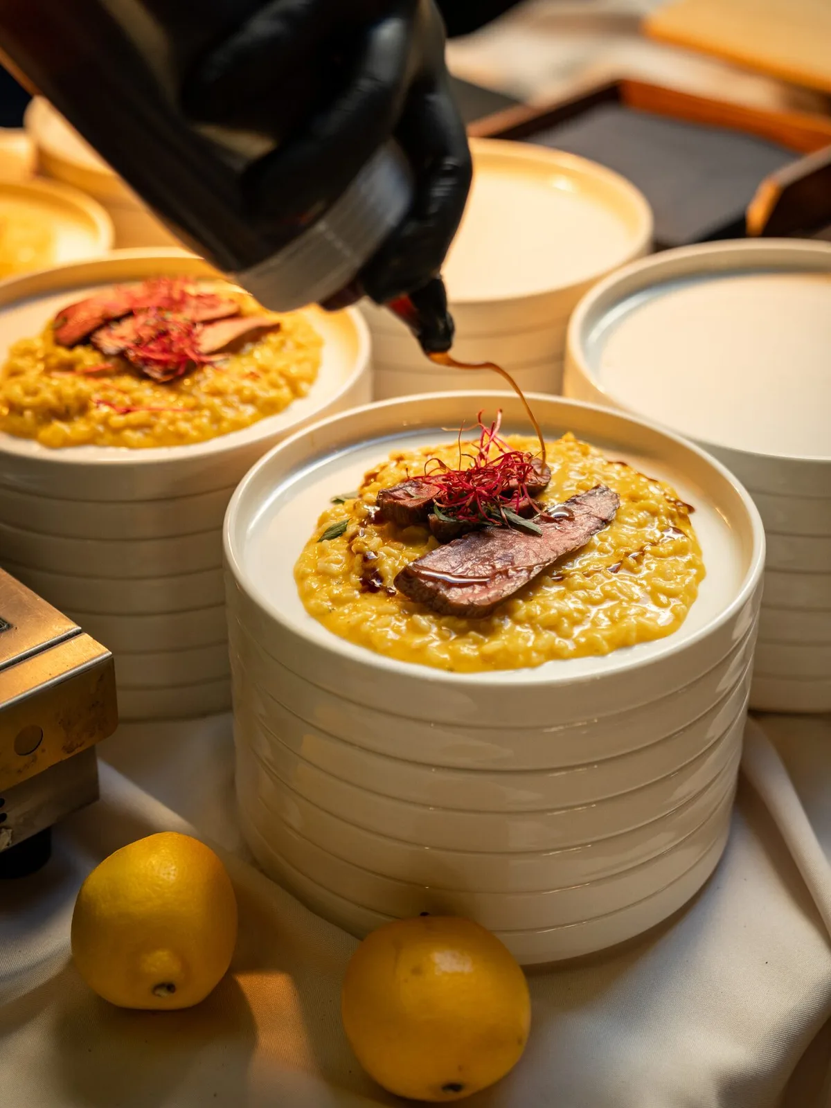 Saffron risotto with steak, plating at an event