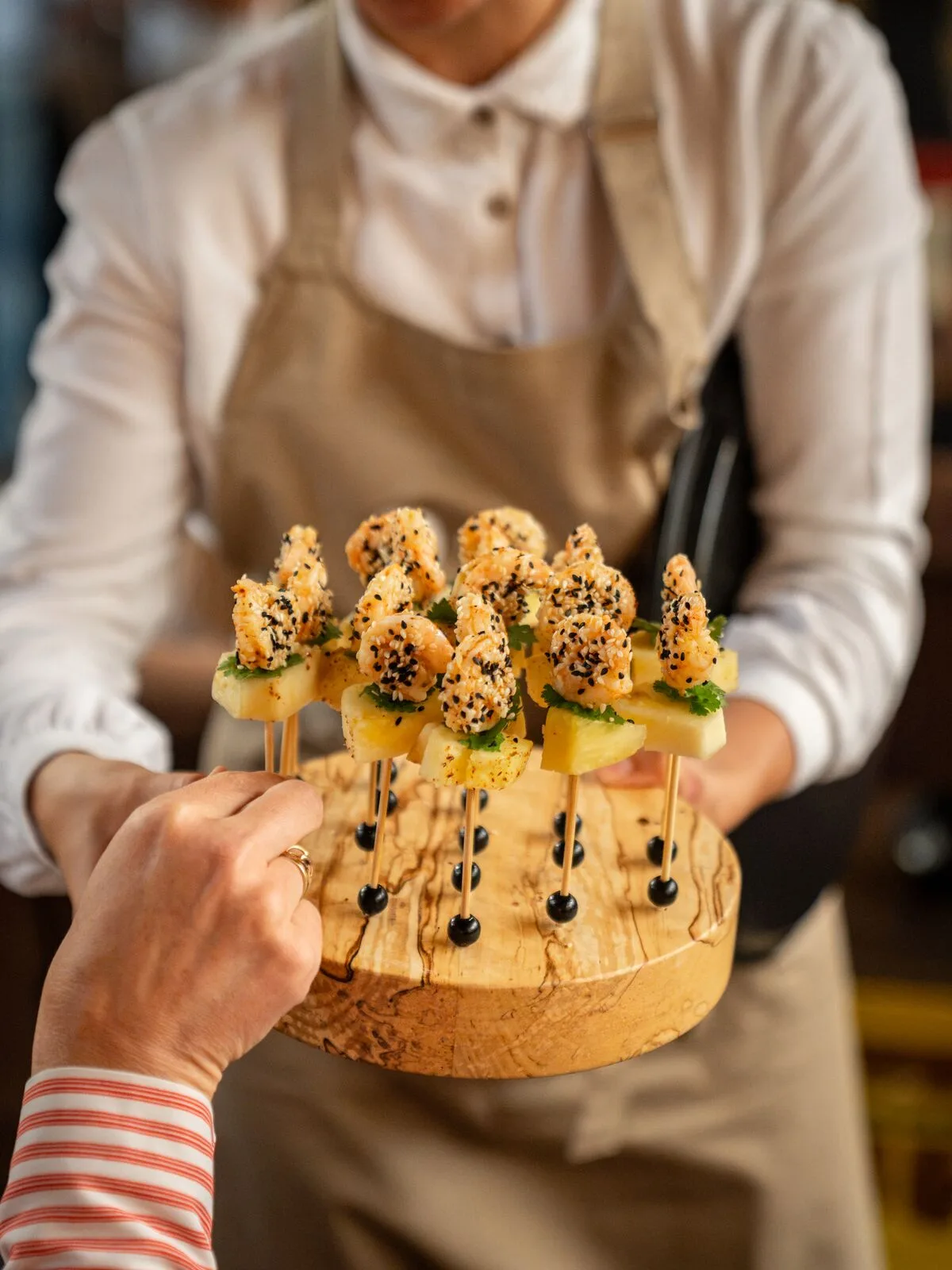 Prawn skewers with pineapple on a wooden tray