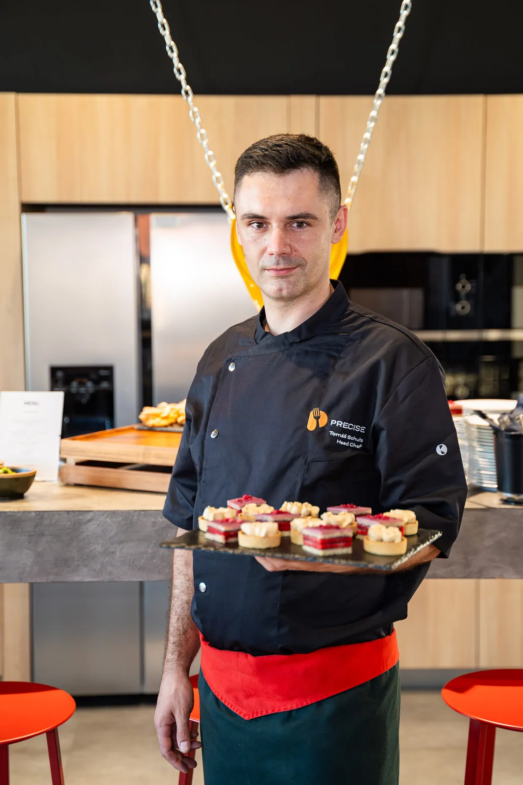 Precise chef with desserts on a tray