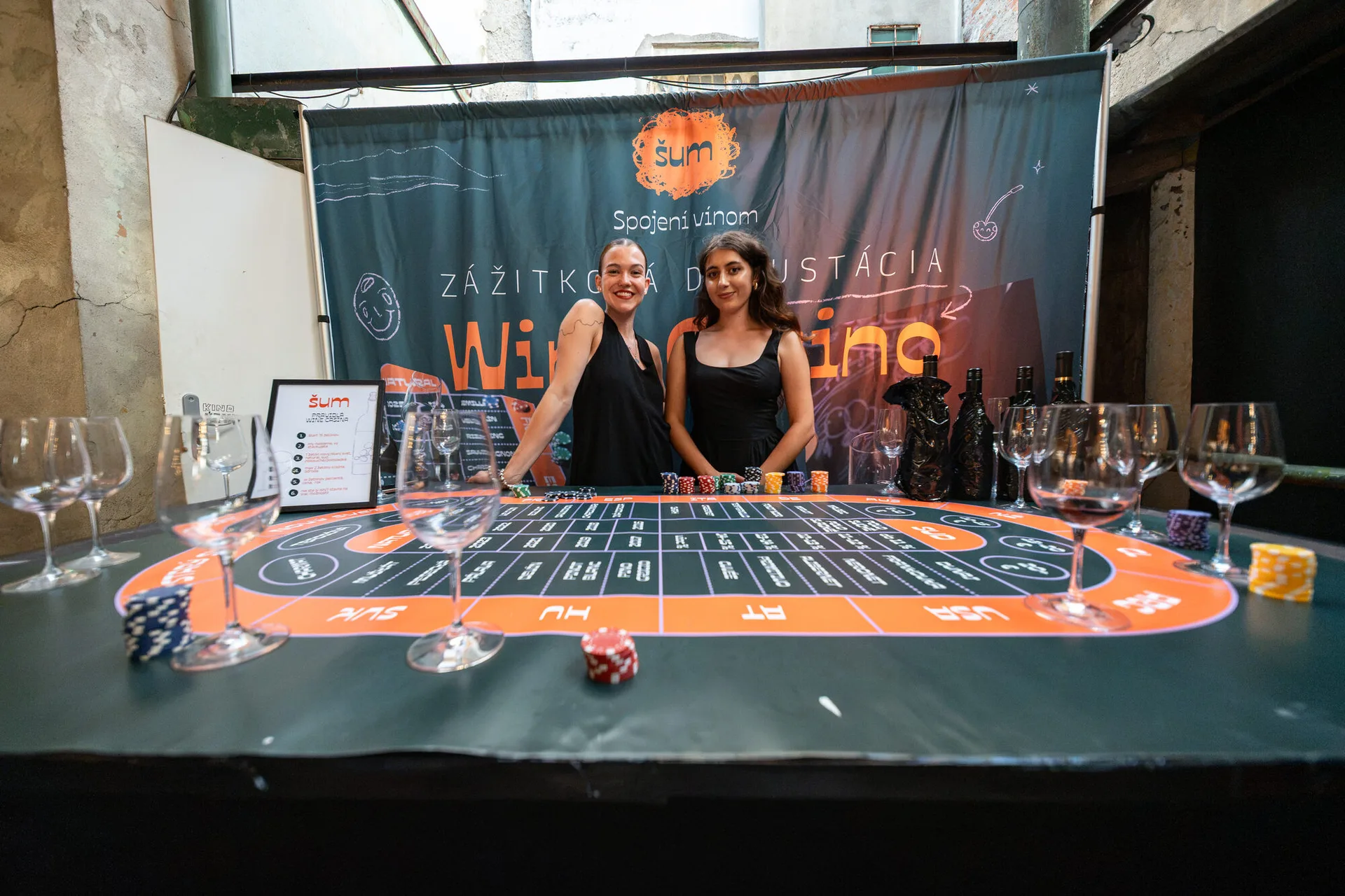 Wine Casino, guests betting and tasting wines at the gaming table with sommeliers from šum